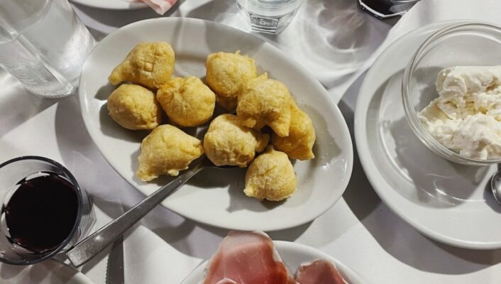 an overhead photo of plates of coccoli at Coccoli, prosciutto, and straciatella at I’Brindellone