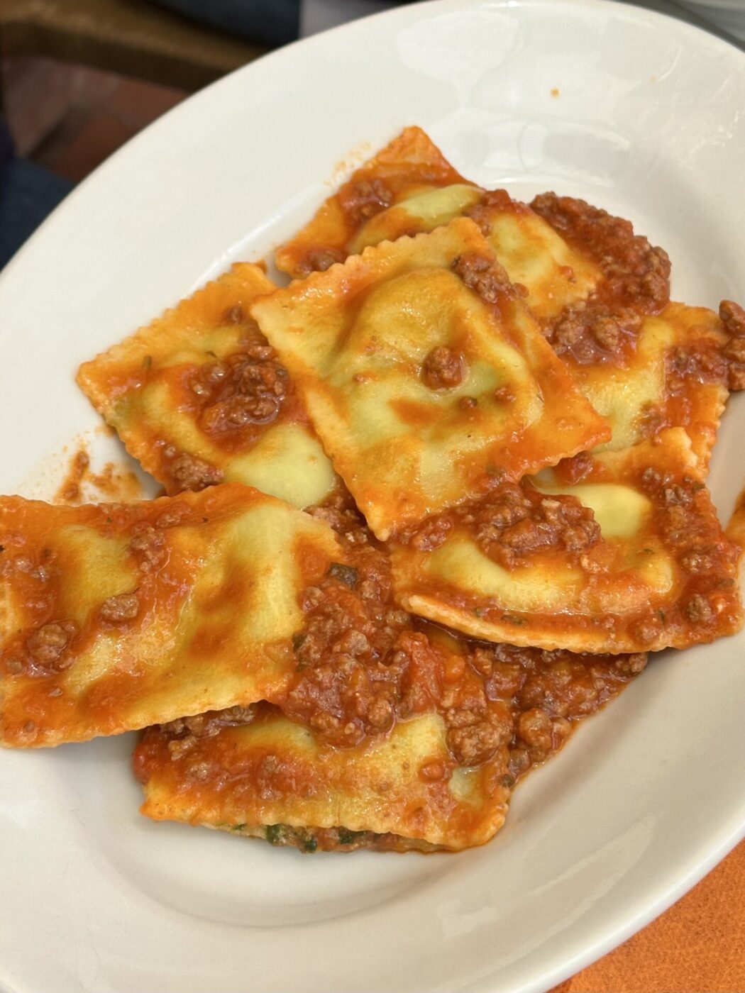 a platter of ravioli with red sauce in Florence called tortelli di mugellani
