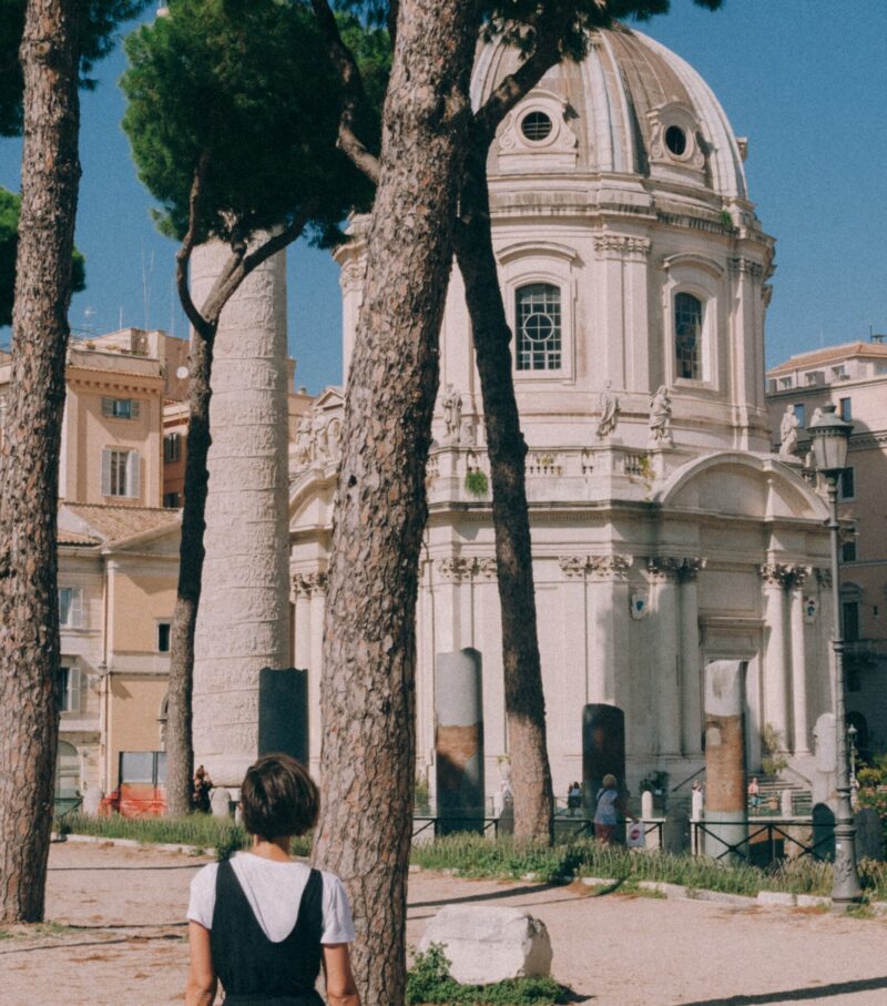 an image of a chapel at the Roman forum with a woman walking in the foreground