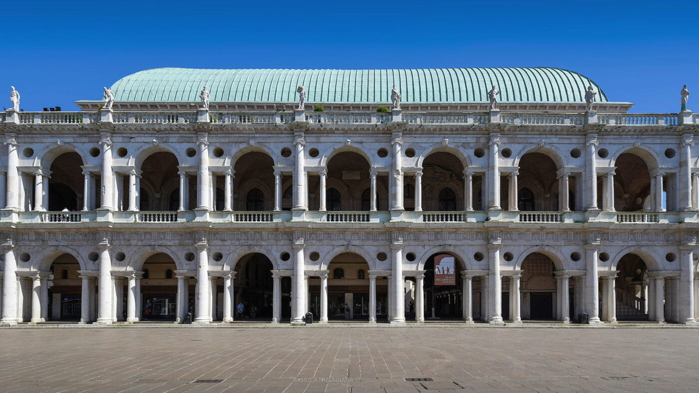 the exterior of the Basilica of Vicenza showing 14 arches and a light green roof and statues on top