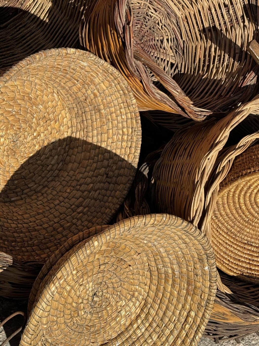 a collection of baskets for sale at a market in Puglia