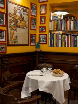 an image of a table in a corner at La Libera and the yellow walls are covered with photos
