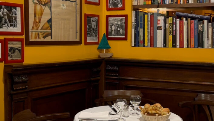 an image of a table in a corner at La Libera and the yellow walls are covered with photos