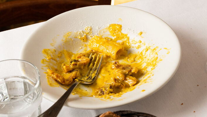an image of an almost empty plate of carbonara from Al Velavevodetto on a table next to bread