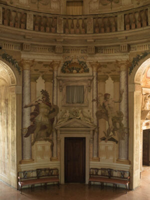 the interior of Villa La Rotonda with frescoed on the wall between two mirroring rounded hallways