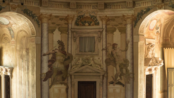the interior of Villa La Rotonda with frescoed on the wall between two mirroring rounded hallways