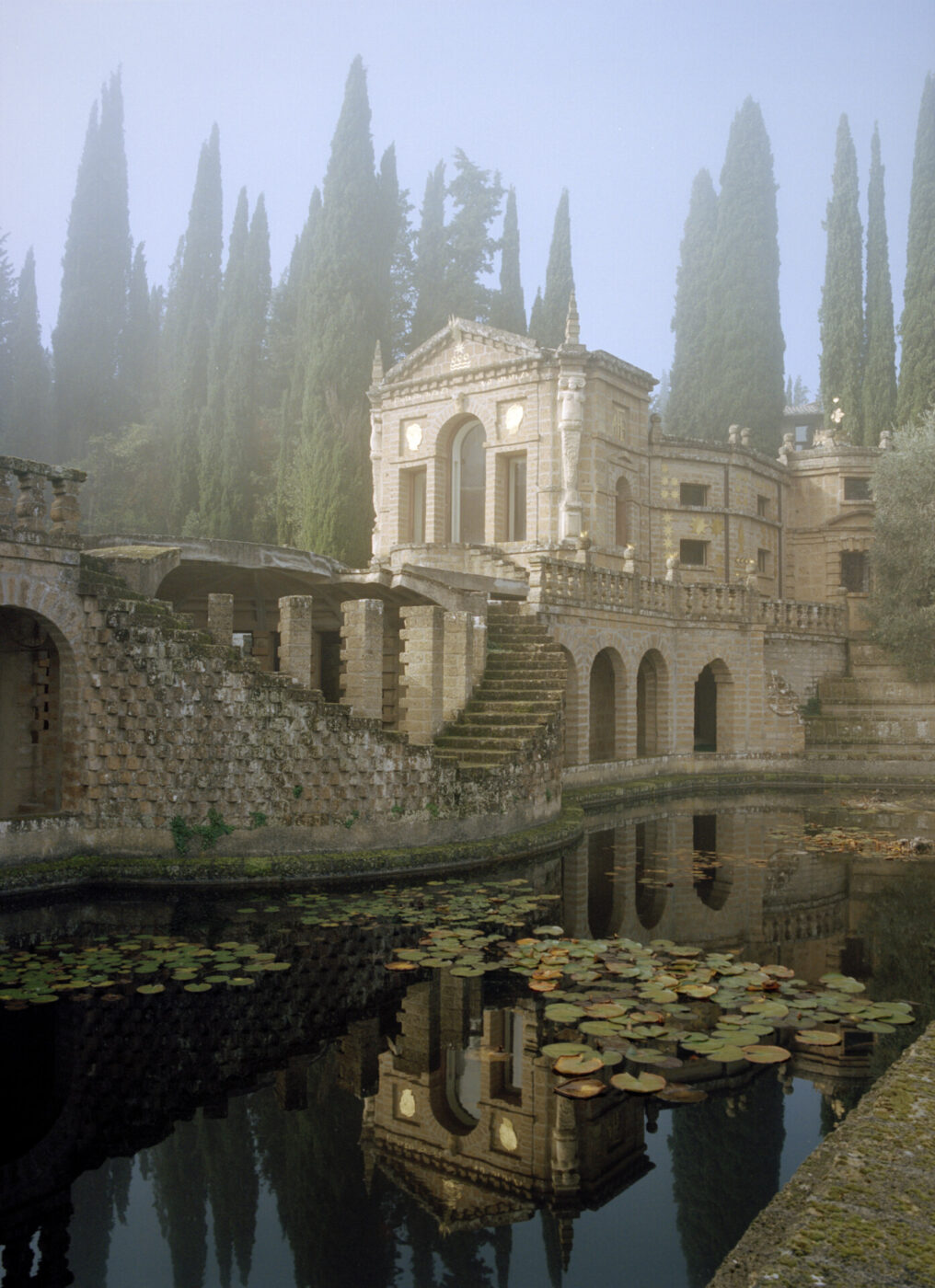 an image of a lake in front of a large windy castle at La Scarzuola