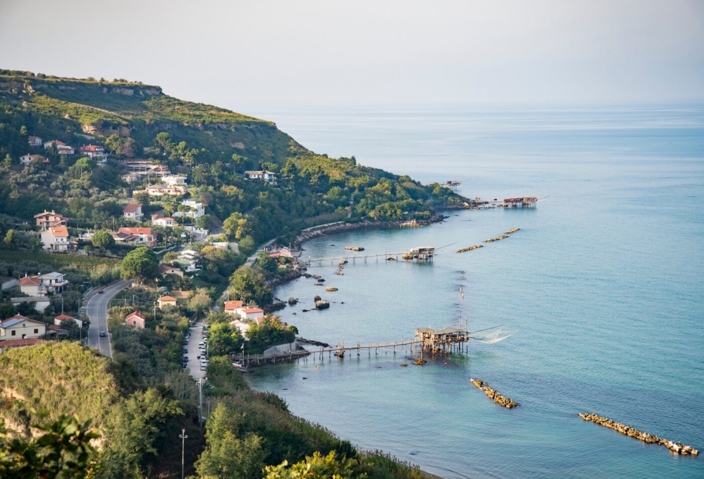 an image of a piece of the trabocchi coast with a curving coastline and the trabocchi out over the water