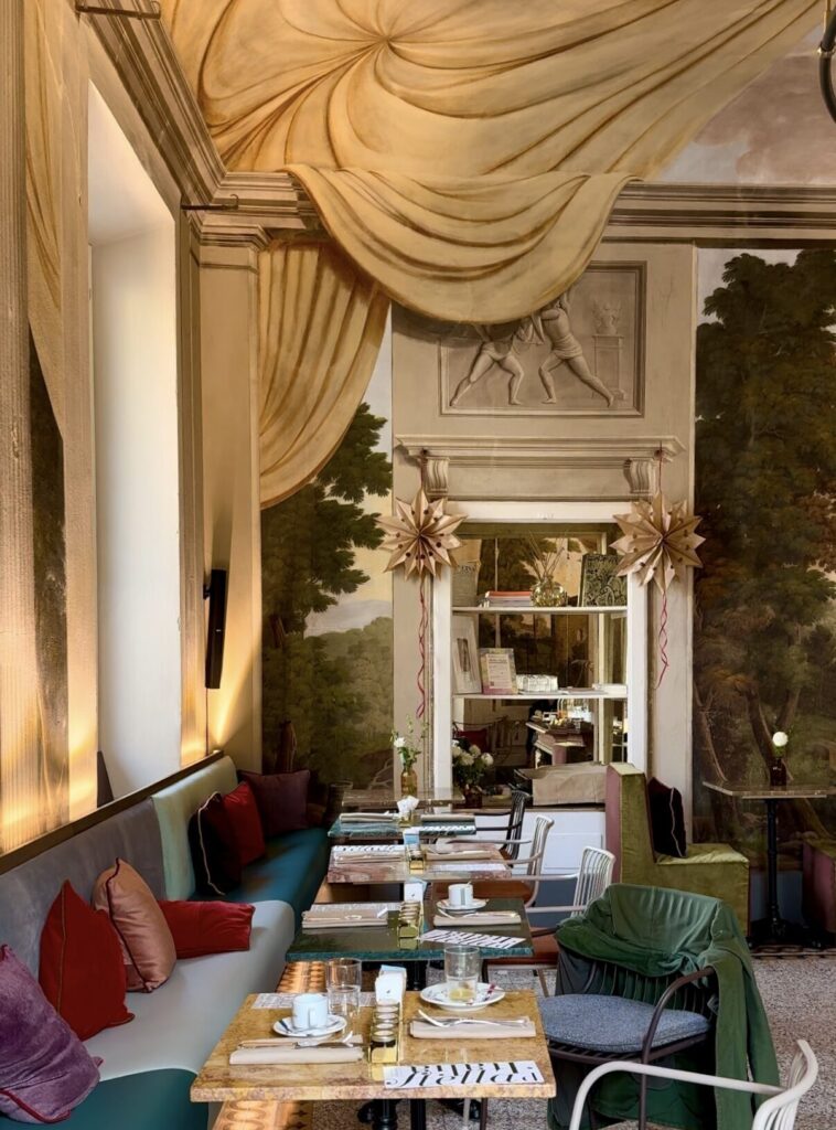 the interior breakfast area at stella d'italia with small tables along one long booth