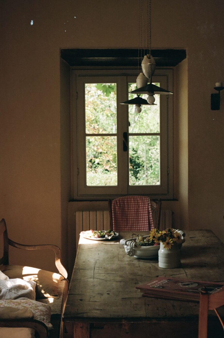 an image of a large table inside a Tuscan farmhouse looking out the sunny window