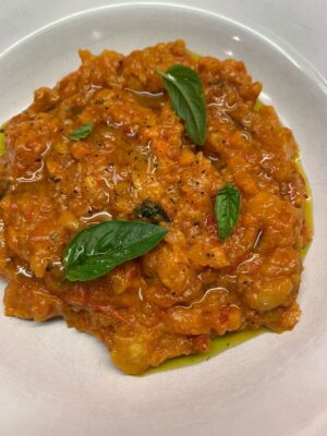 a bowl of pappa al pomodoro, a thick tomato soup with basil on top