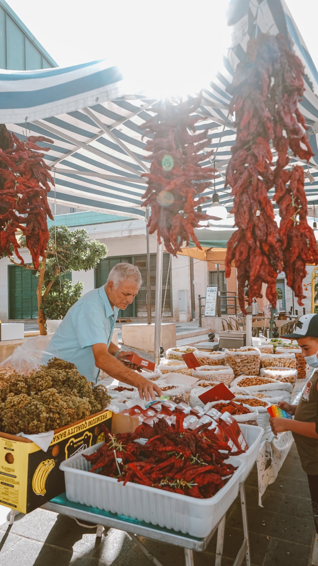 Vendor at Matera market selling pepperoni cruschi