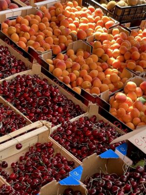 an image of boxes of peaches and cherries at a fruttivendolo
