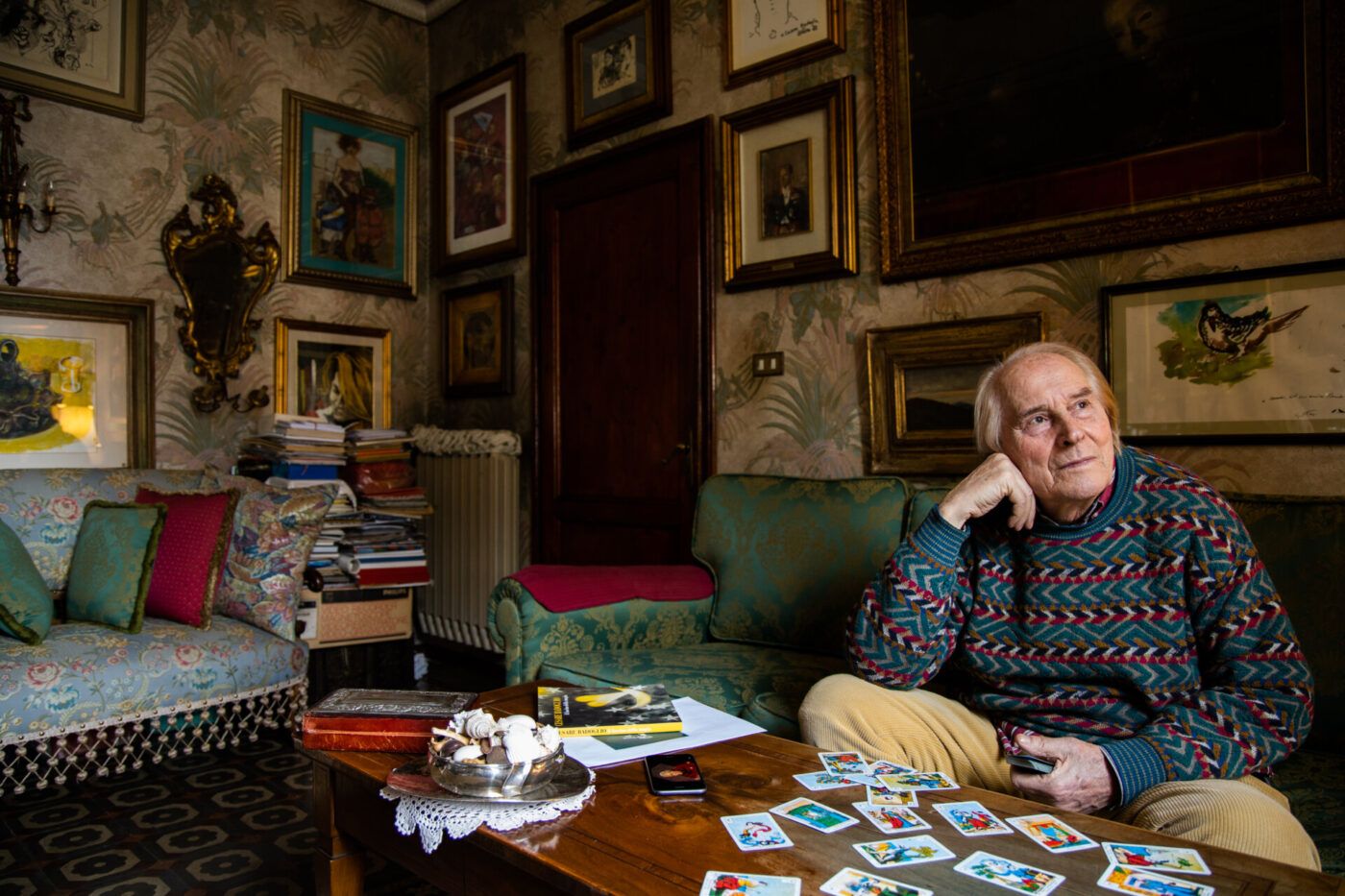 Cesare Chiti (Mago Badoglio) sitting in his house at a table filled with tarot cards