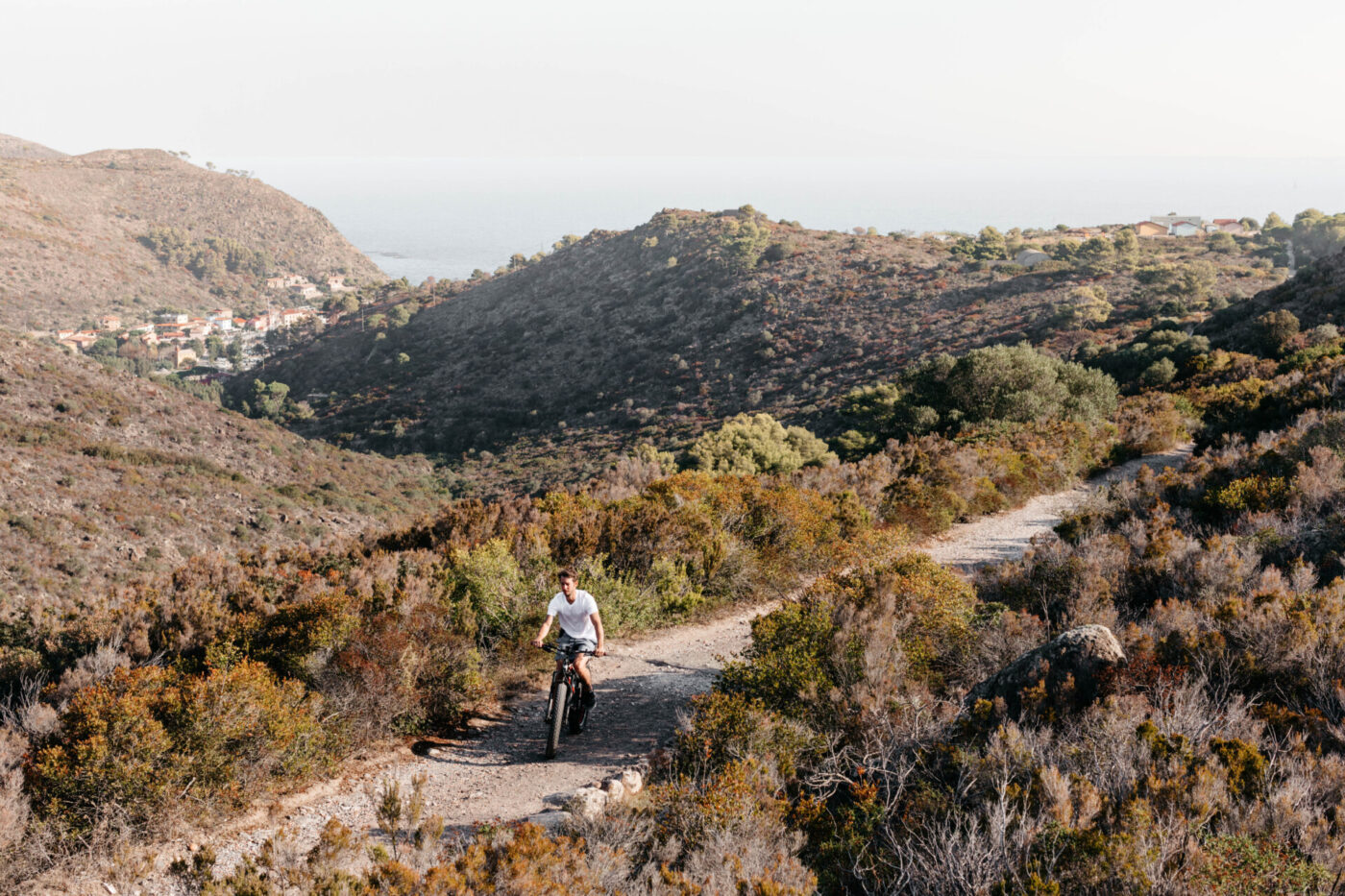 an image of someone biking along a path on Capraia in the fall