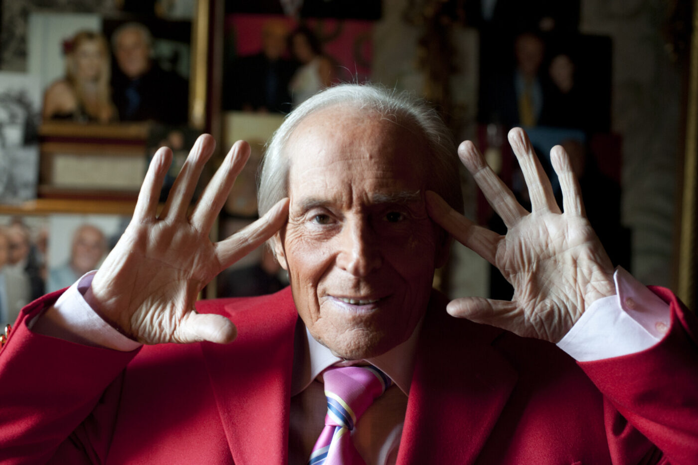 an image of Cesare Chiti (Mago Badoglio) up close holding his hands up to his ears