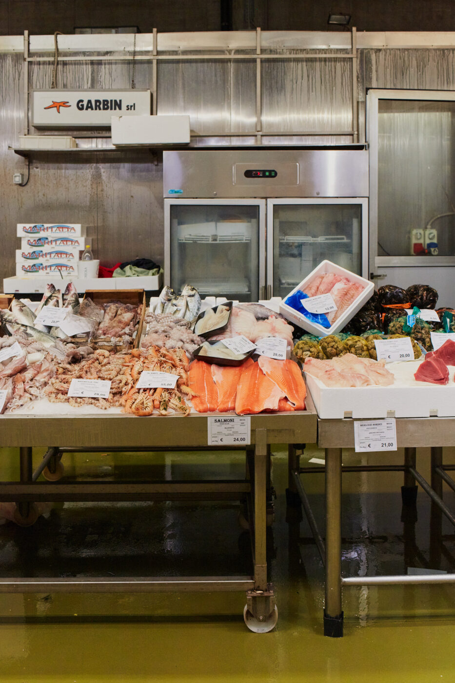 a stand at the milan fish market with lots of raw fish