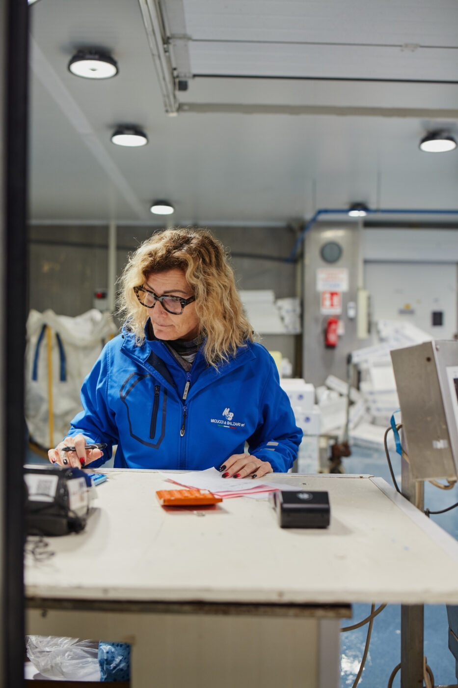 a woman typing numbers into her calculator to add up the total prices for some fish at the milan fish market