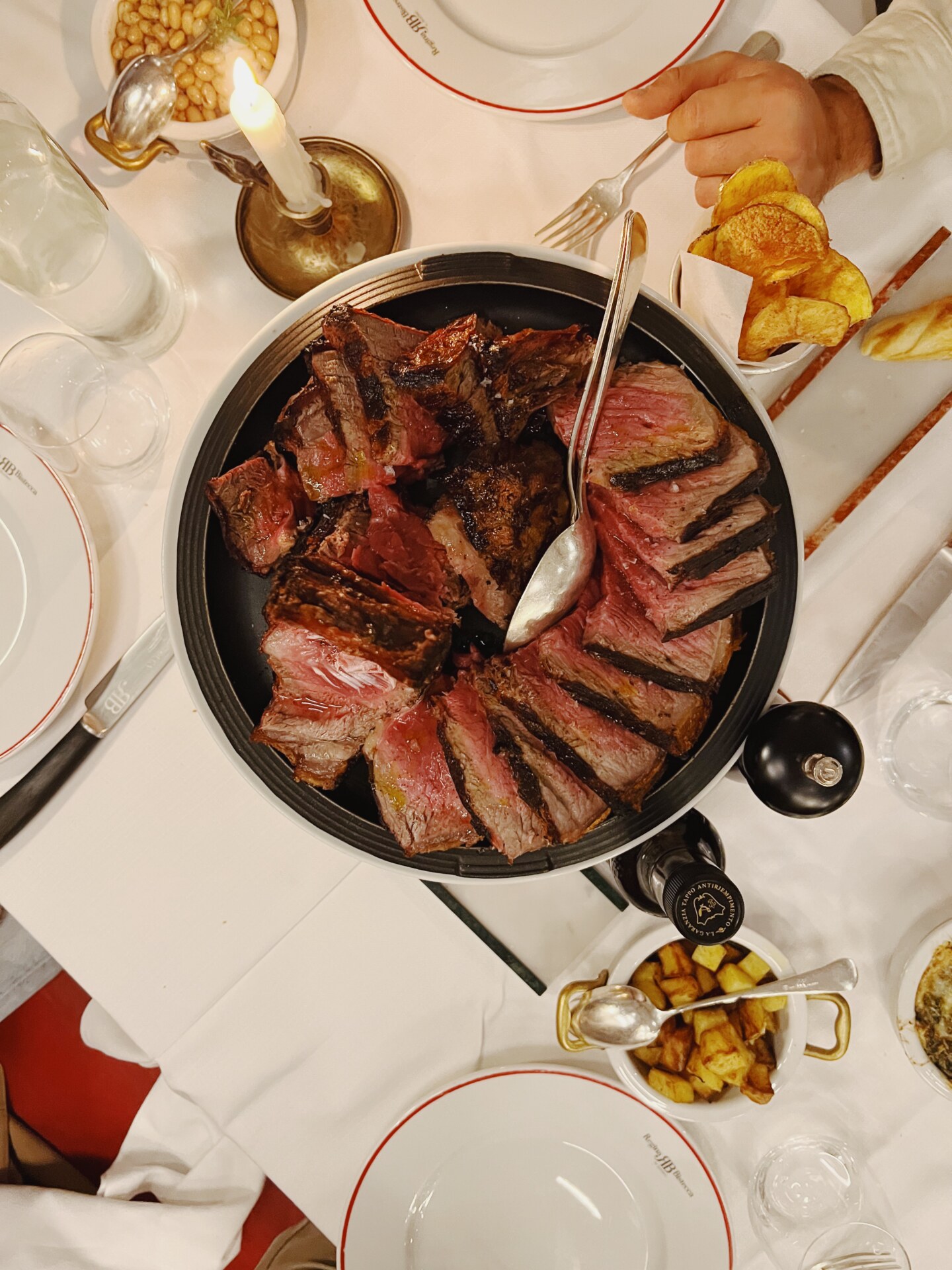 an overhread image of a cast iron pot filled with bistecca fiorentina at Regina Bistecca