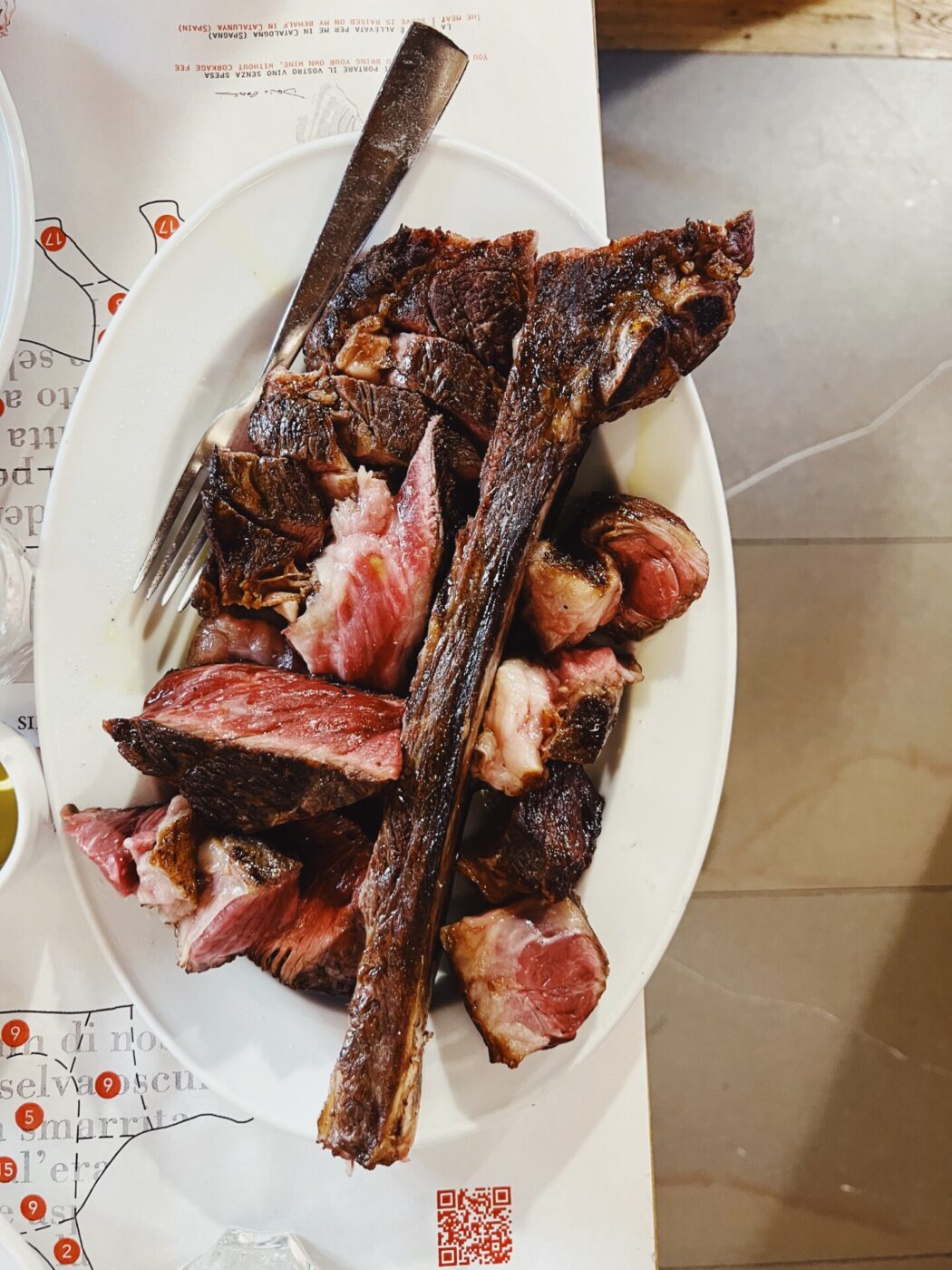 bistecca fiorentina not cut pretty on a white dish at Antica Macelleria Cecchini