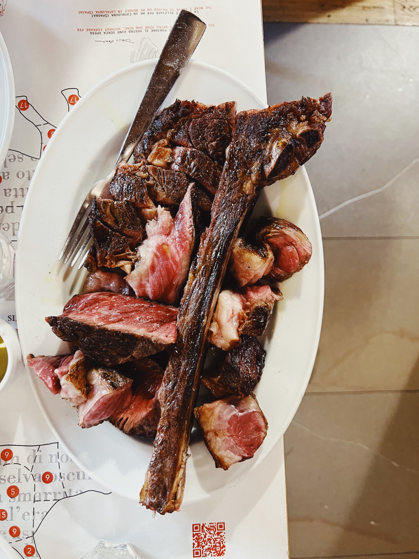 bistecca fiorentina not cut pretty on a white dish at Antica Macelleria Cecchini
