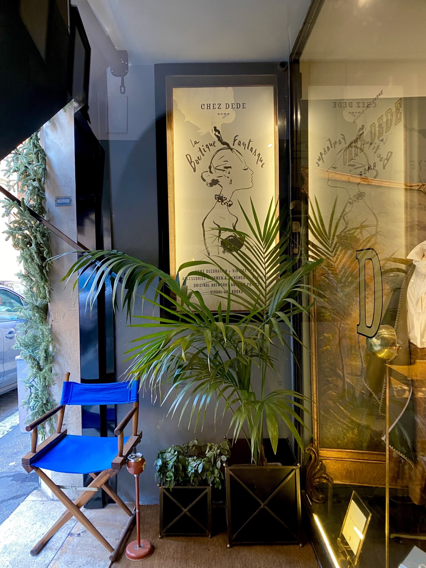 the entryway to Chez Dede with plants and a painting of a woman