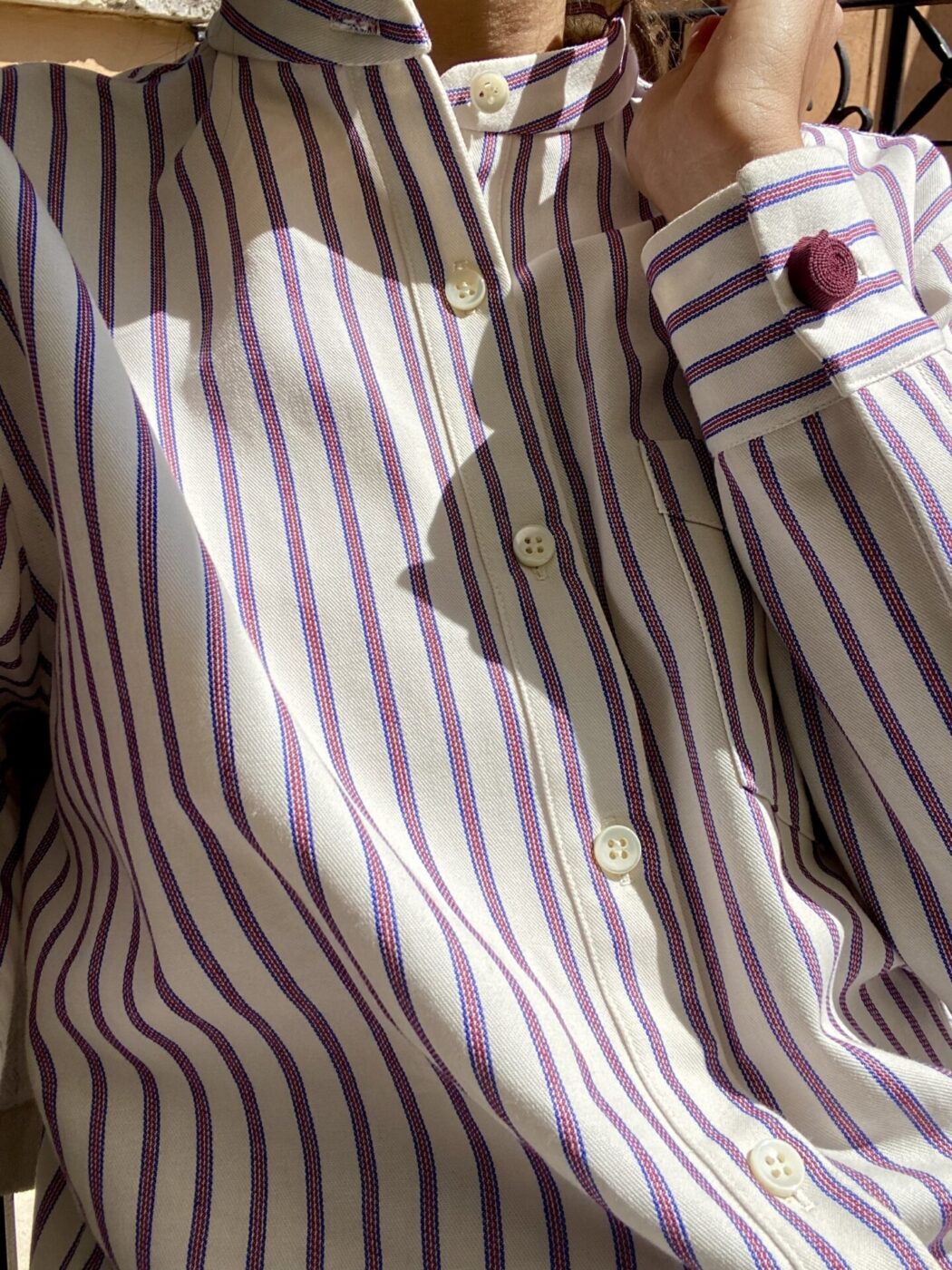 a man wearing a white and purple Striped shirt