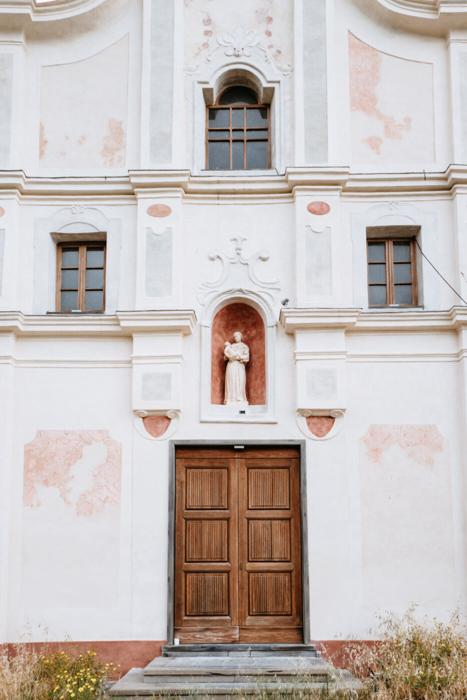an image of an ornate entryway door with la madonna on top at Forte San Giorgio