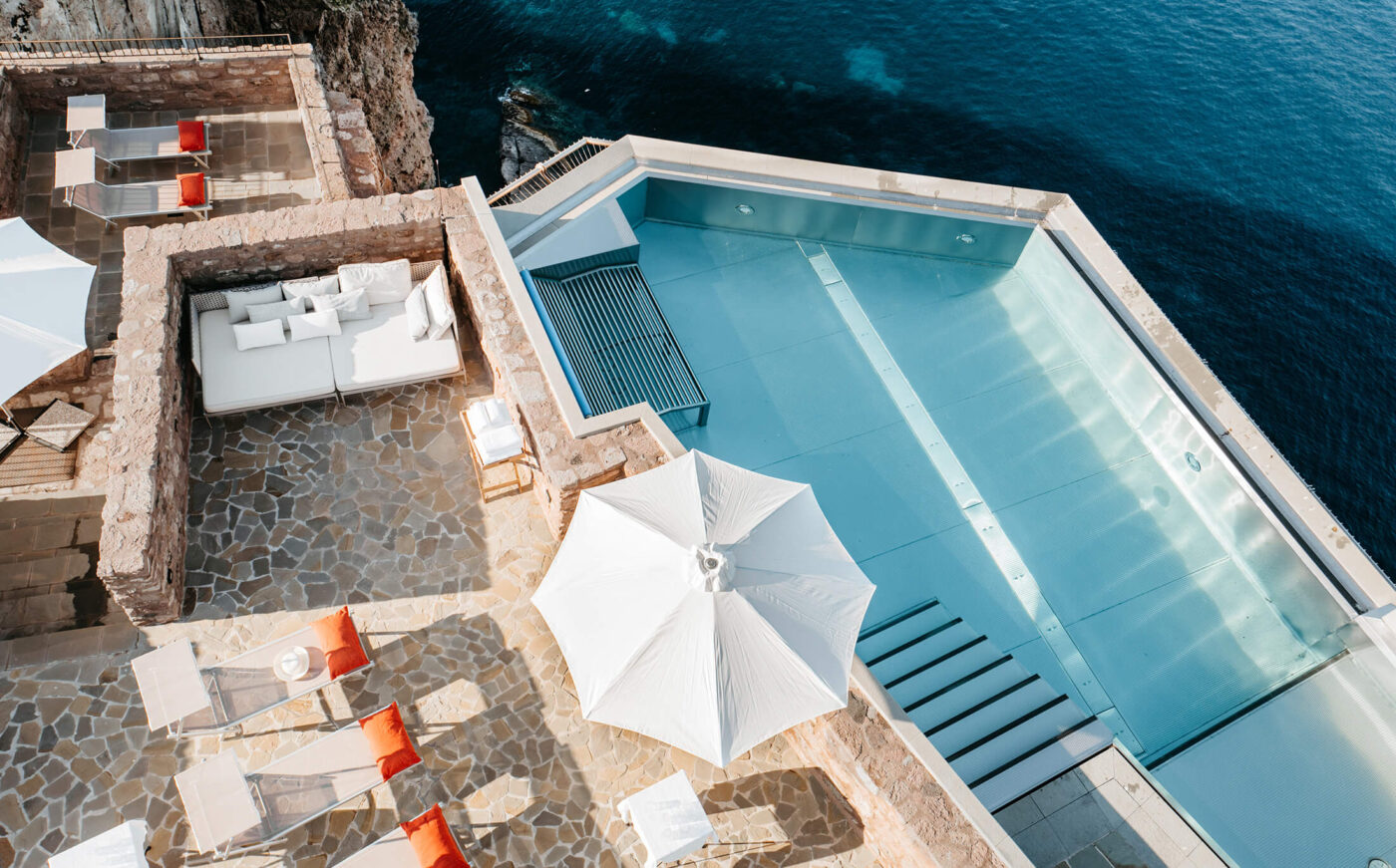 an overview of the pool at forte san giorgio with the sea beneath and