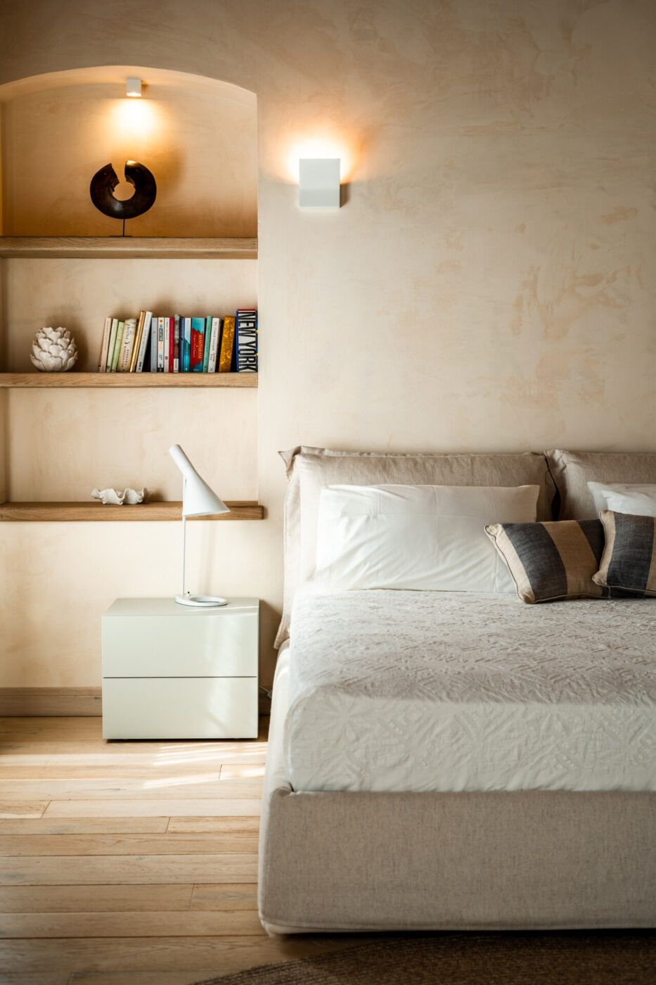 a room at Forte San Giorgio with a clean made bed, and inset shelves