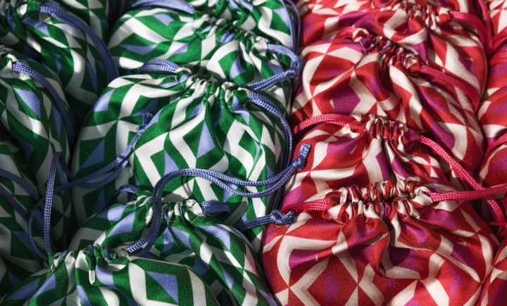 a close up on small silk drawstring bags with geometric patterns in pink and purple or green and blue