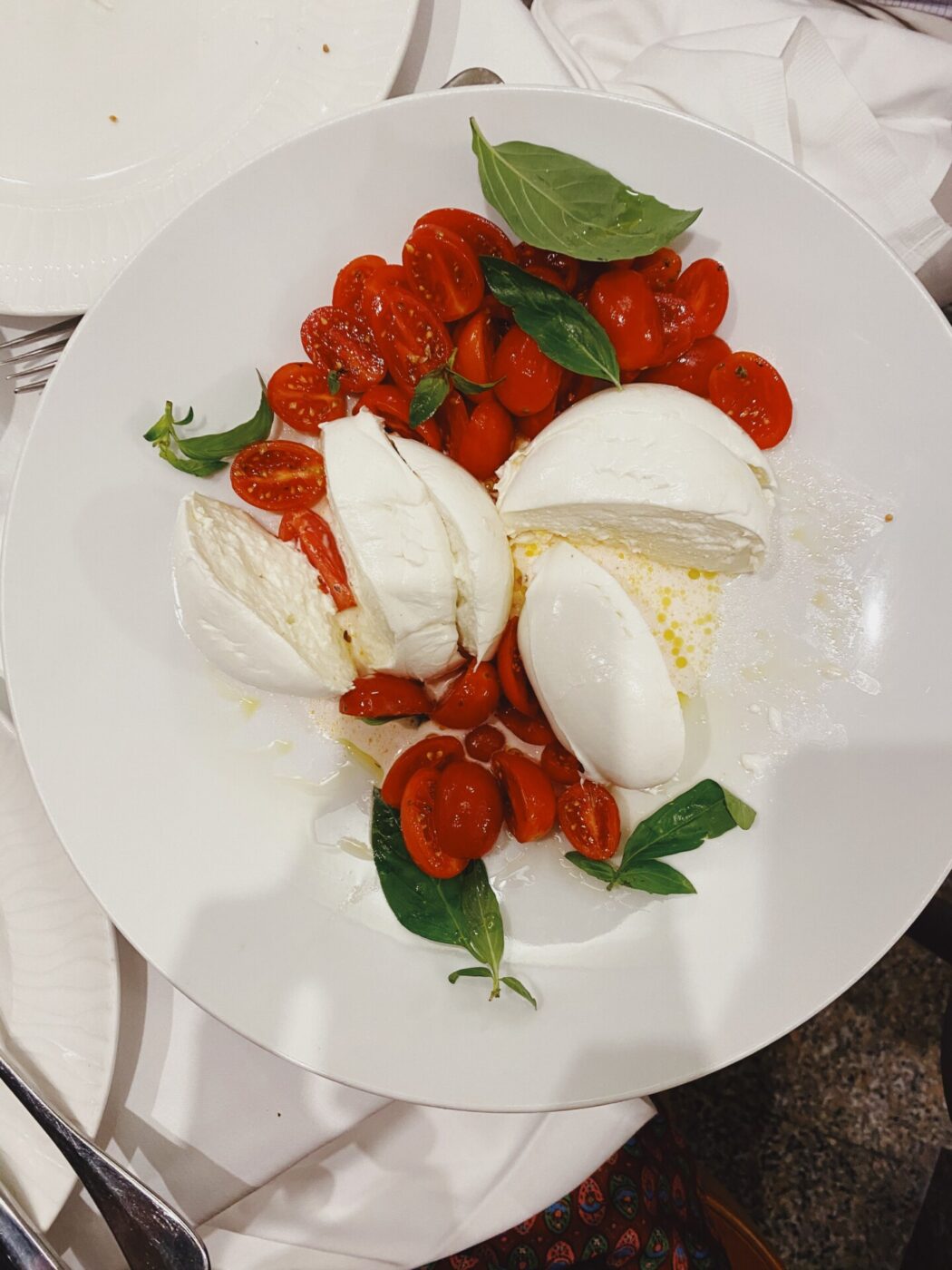 Caprese salad, sliced cherry tomatoes, mozzarella di bufala and basil leaves