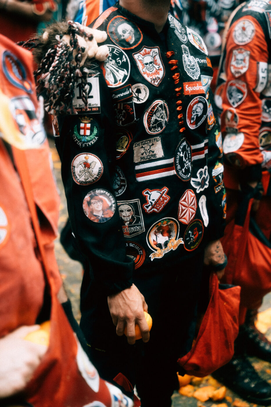 a closeup of the black jacket covered with patches on one of the men on the team of death