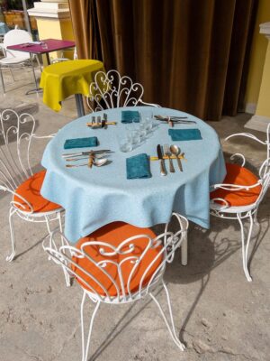 an image of tables at Meteo with orange seat cushions and light blue tablecloth