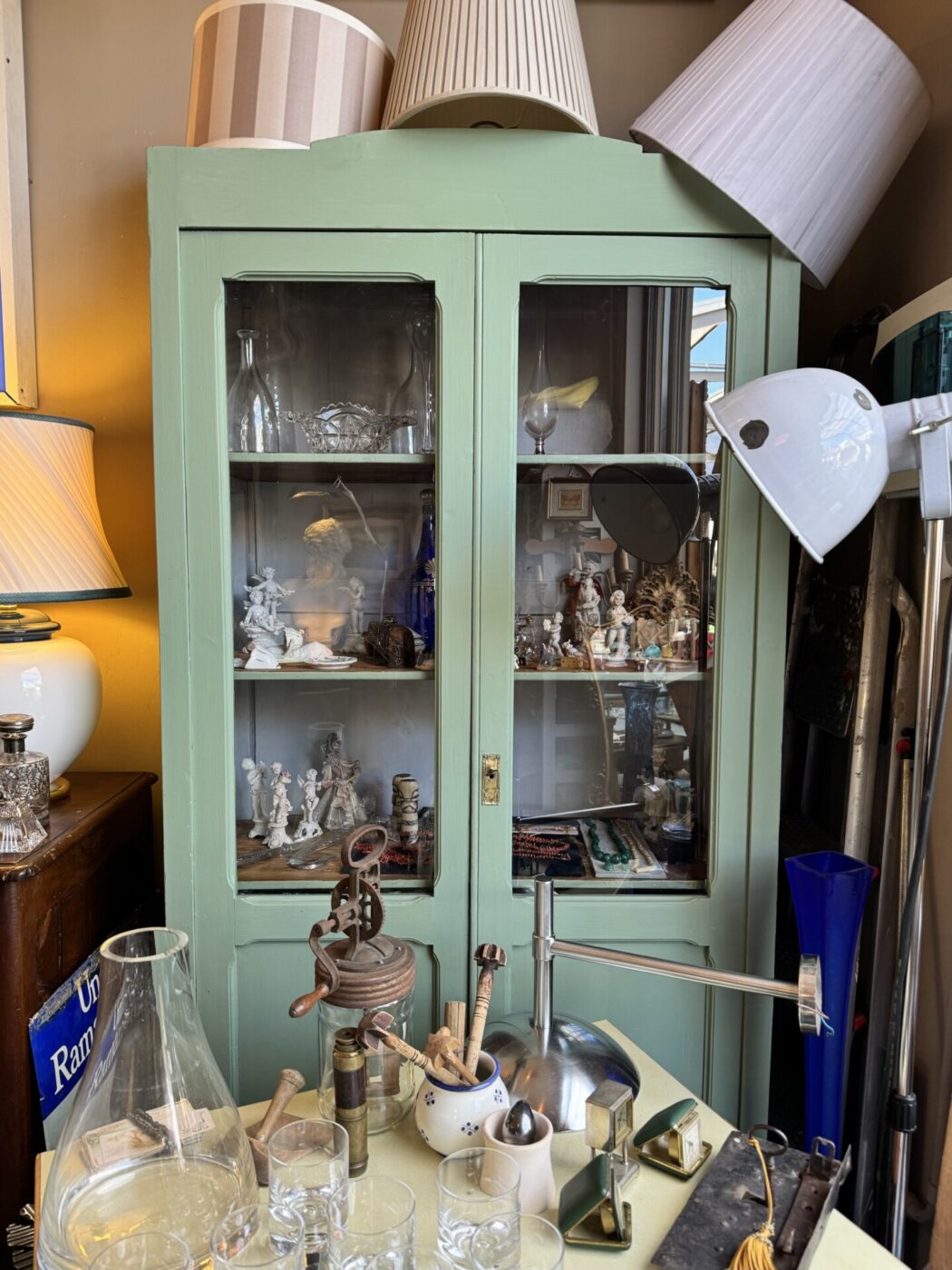 an image of a pale green cabinet in a vintage market in tuscany