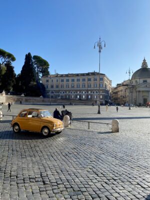 a bright yellow fiat in Piazza del Popolo in Rome