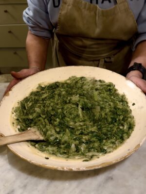 an image of a woman holding a large bowl of fave e chicoria at a masseria in puglia