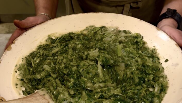 an image of a woman holding a large bowl of fave e chicoria at a masseria in puglia
