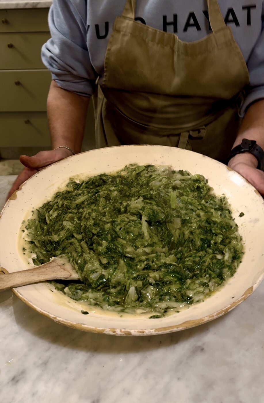 an image of a woman holding a large bowl of fave e chicoria at a masseria in puglia