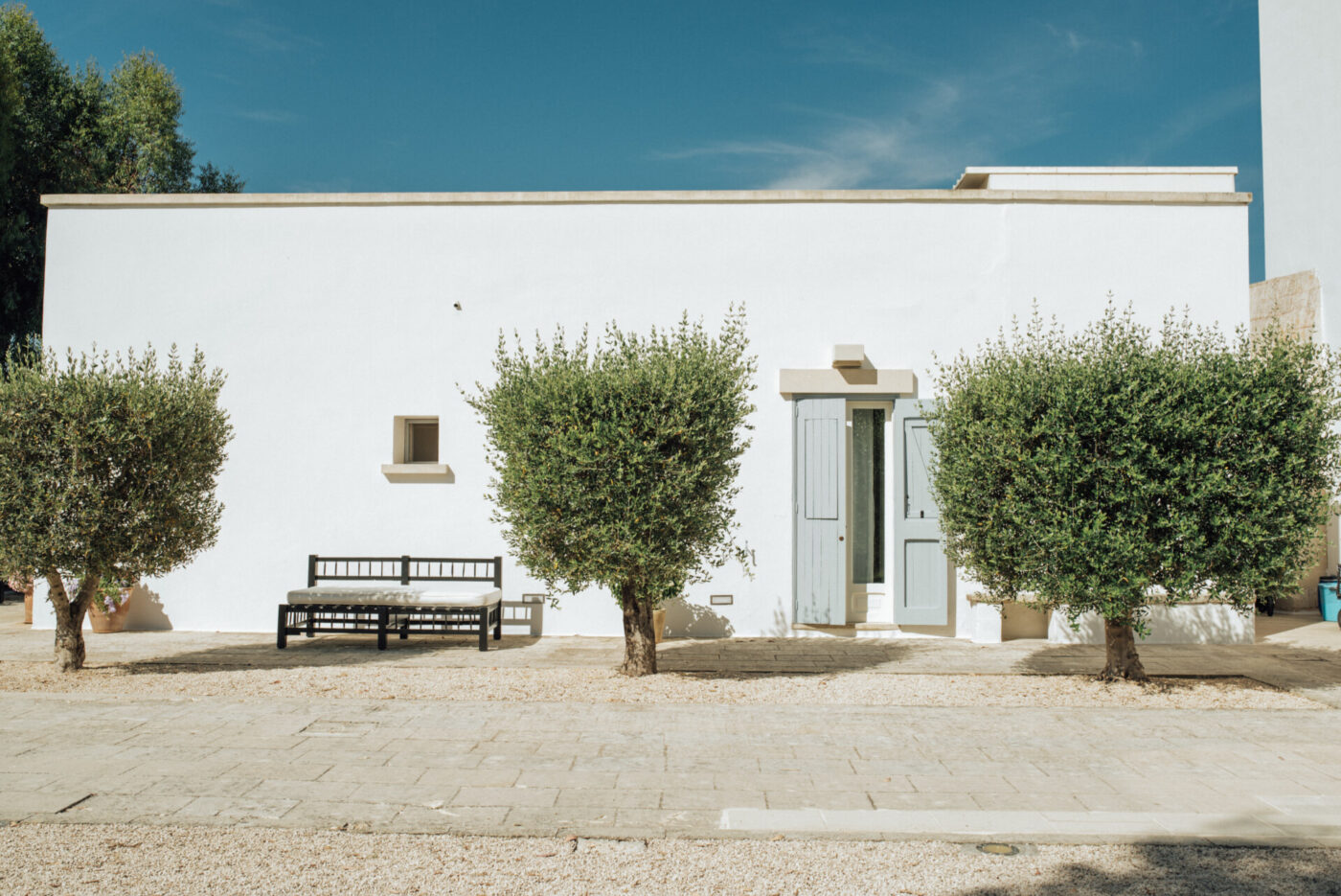 an image of the front of Masseria Montelauro, with white walls and
