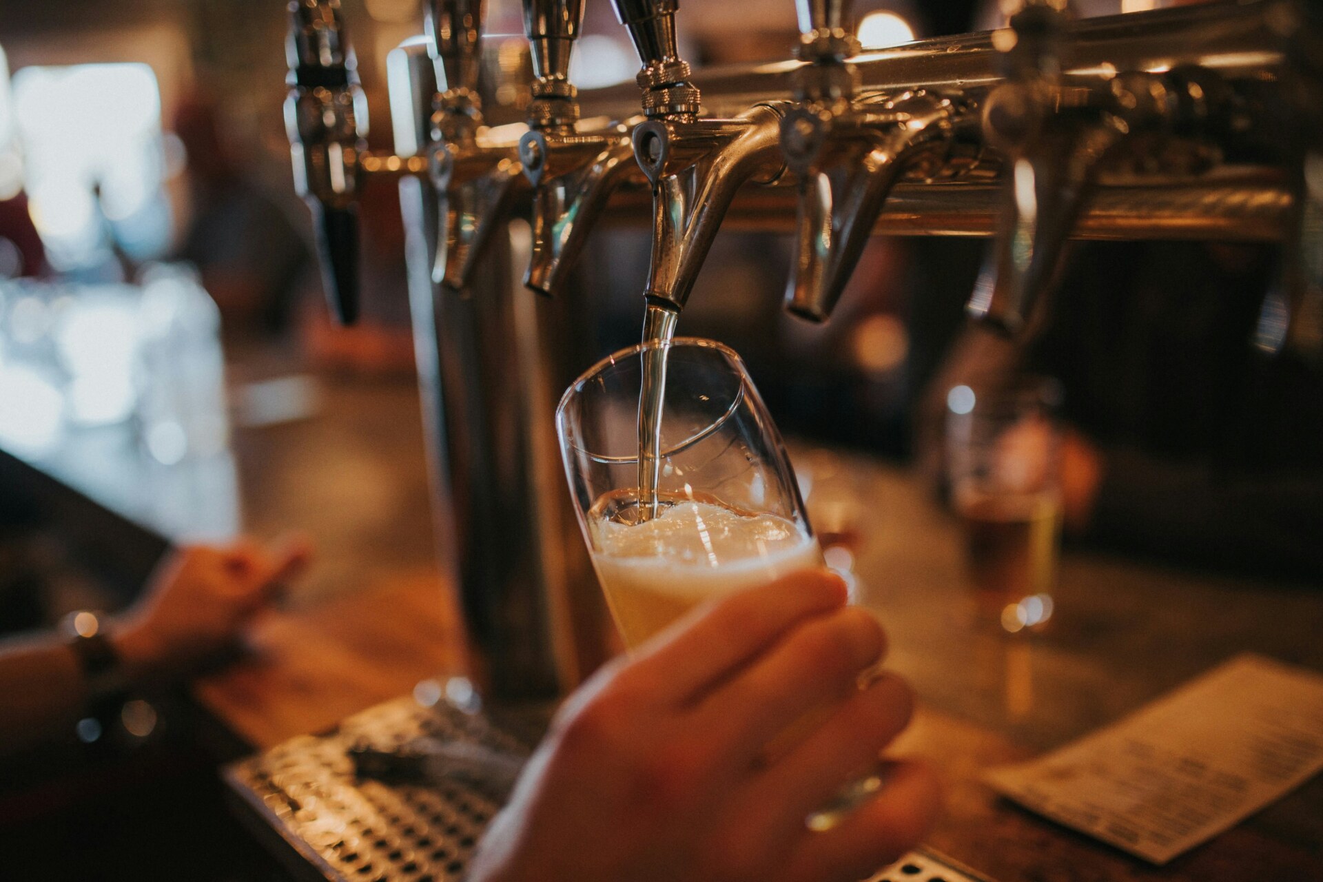 an image of someone filling a glass from a beer tap