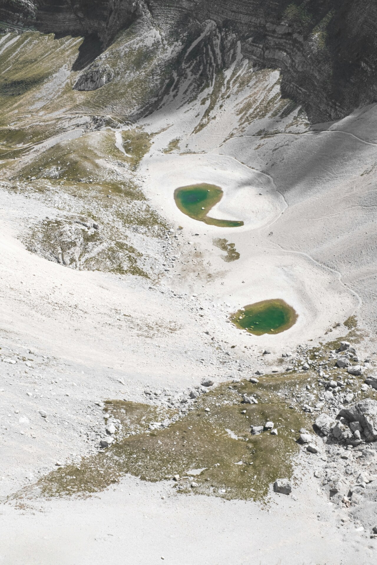 an overhead image of the Pilato Lake, two bright turquoise circles amidst the rocky gray landscape