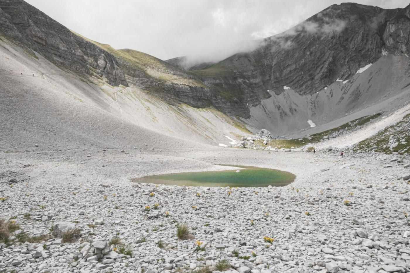an image of the Pilato Lake in Marche with a gray rocky surrounding area to the turquoise lake