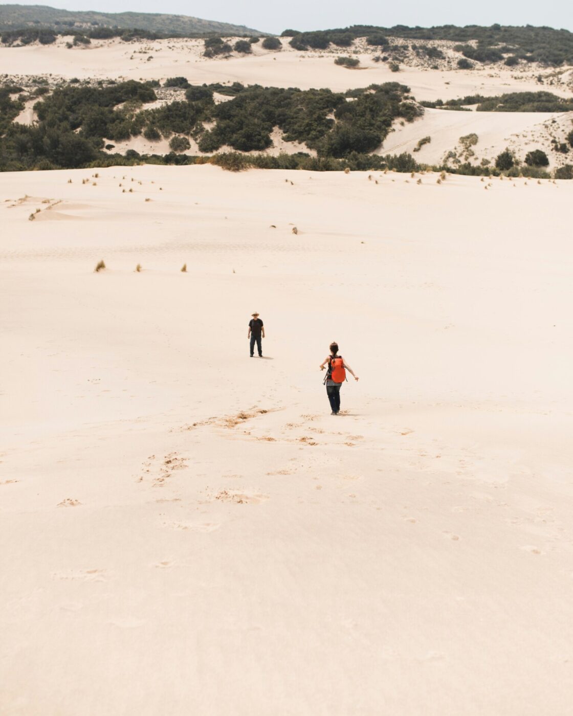 an image of people walking through the sand on the Dunes of Piscinas