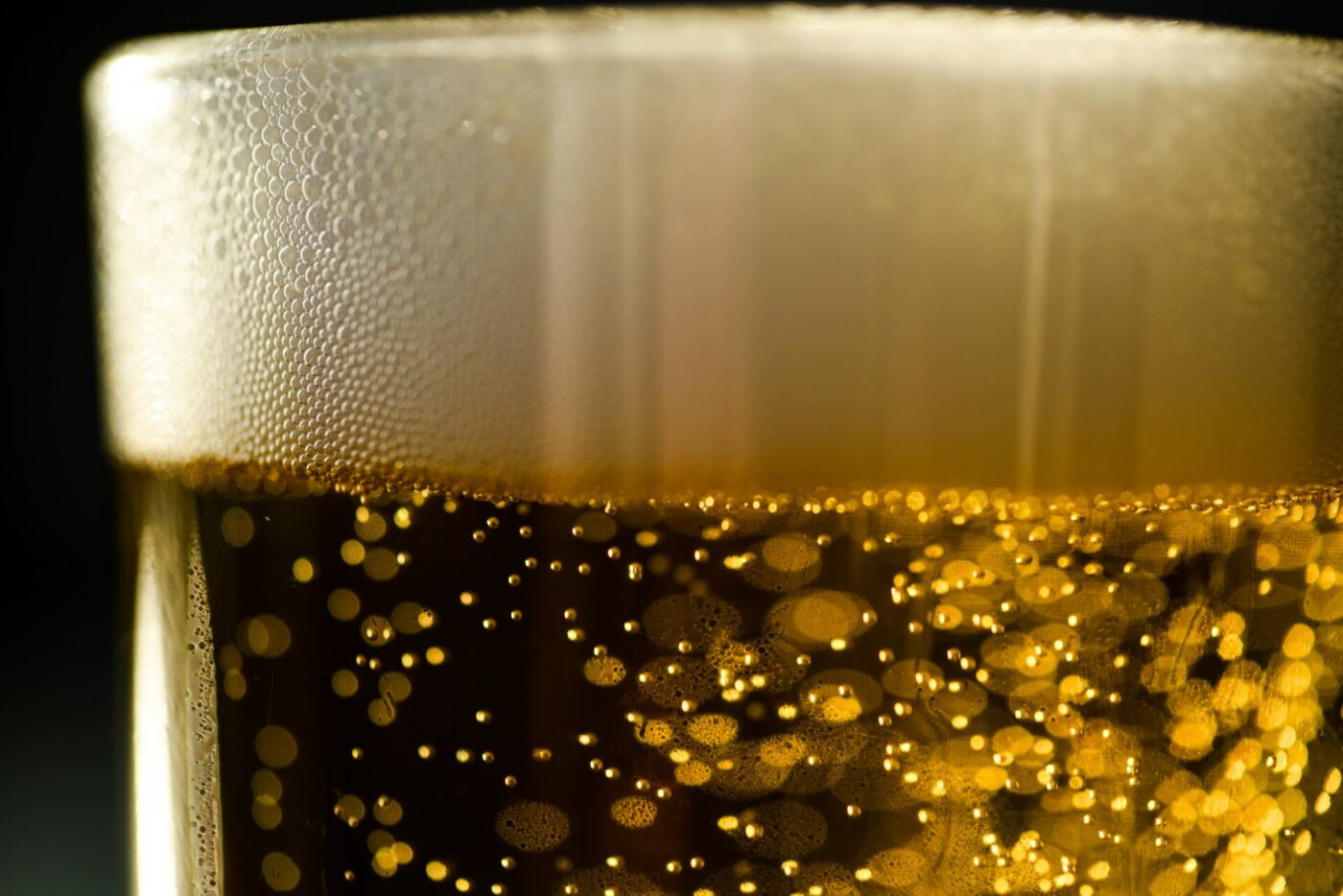 a closeup of the thin layer of foam on top of bubbly beer