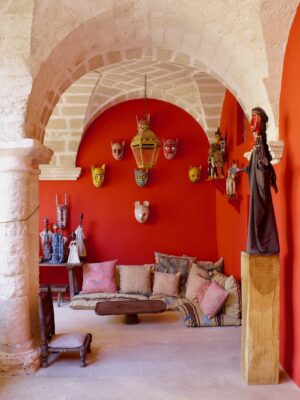 the interior of the Convento di Santa Maria di Costantinopoli with a bright red wall decorated with masks
