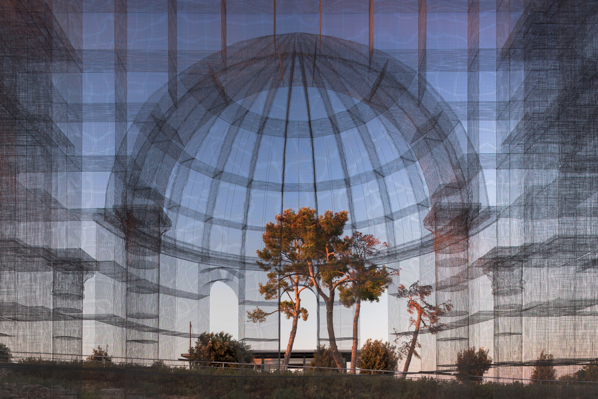 the Basilica di Siponto made of wire and mesh photographed from the inside looking out and you can see trees through it