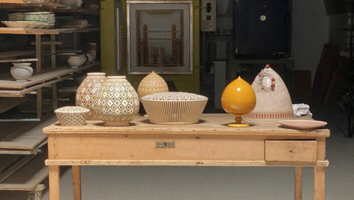 A variety of ceramics sitting on a wooden desk in a sort of storage room in Puglia