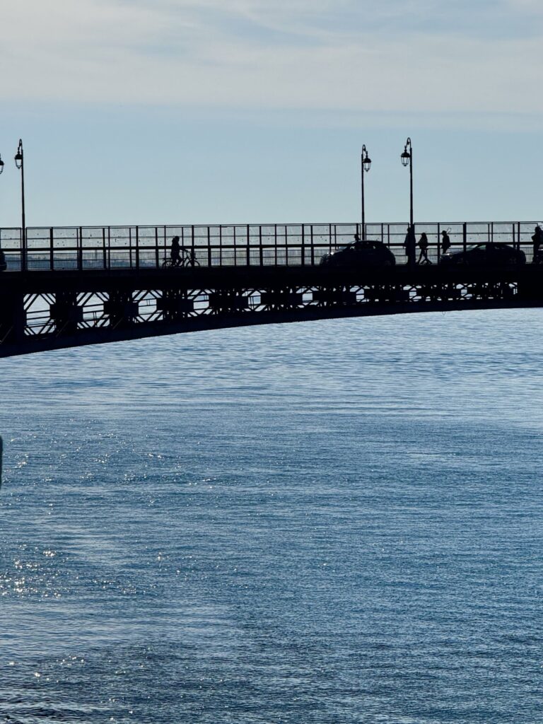 an image of a car bridge in Taranto over the sparkling blue water