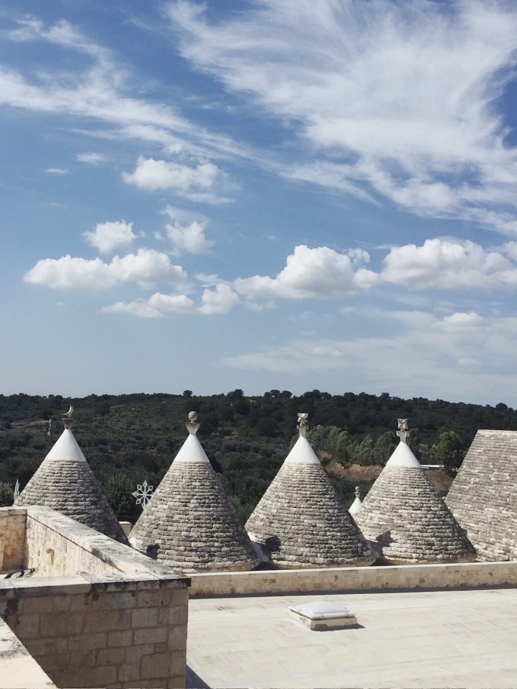five conical trulli houses in the Puglian countryside